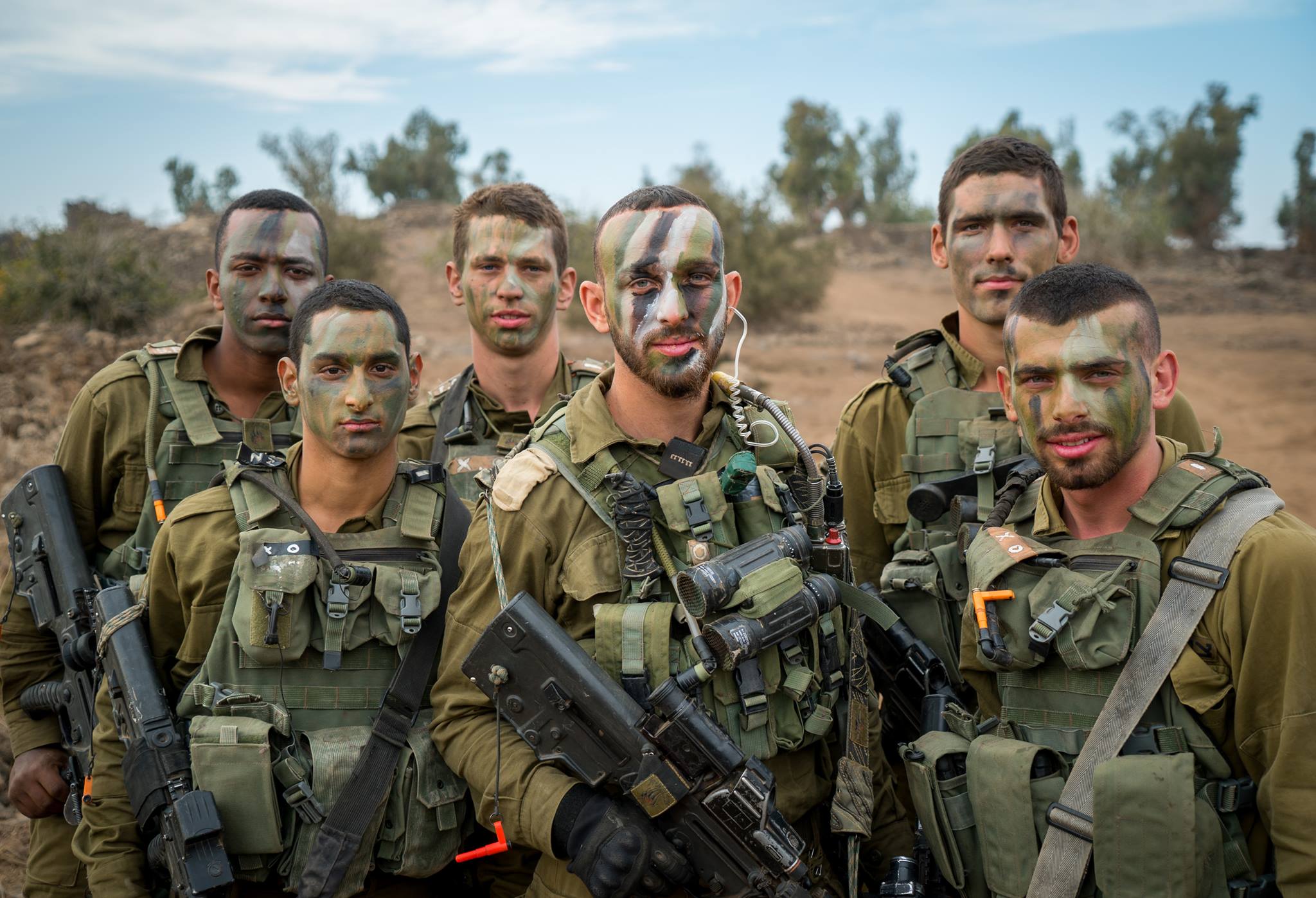 A group of IDF soldiers with full gear and war painted faces