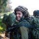 IDF soldier in full gear out in the field smiling