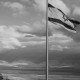 black and white Israeli flag against cloudy sky and mountain view